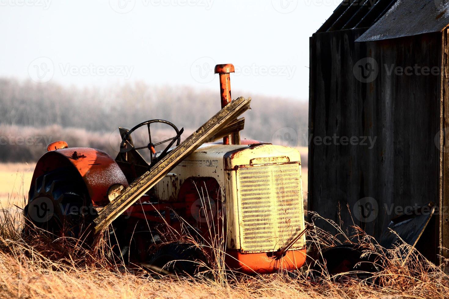 Abandoned tractor by old granaries photo