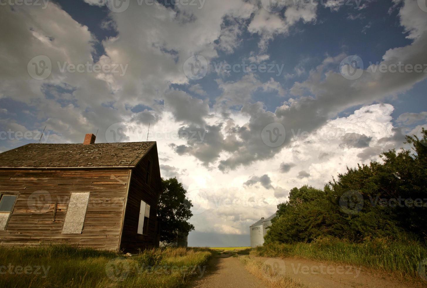 nubes de tormenta detrás de una antigua granja de saskatchewan foto