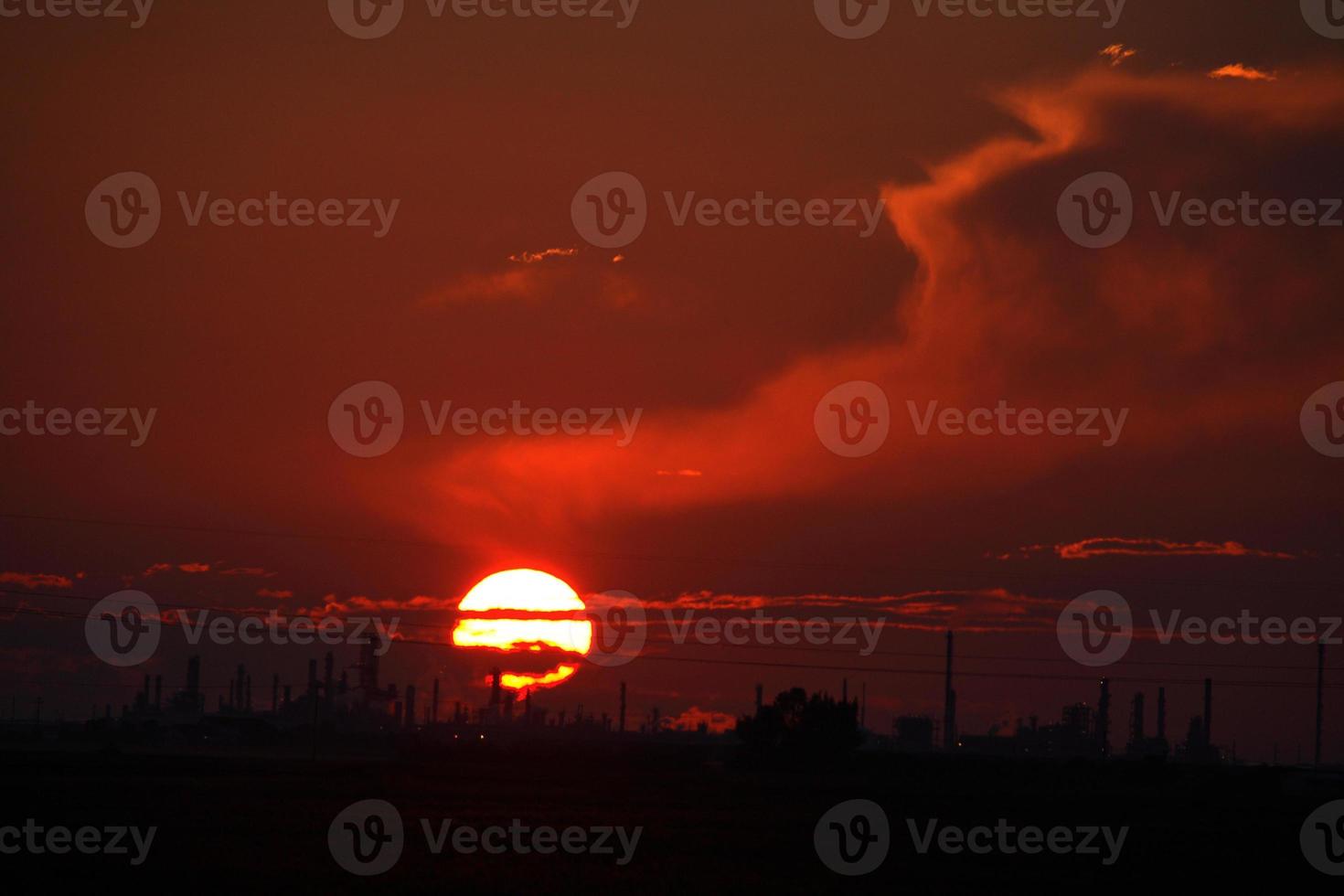 Sun setting behind Regina Oil Refinery in Saskatchewan photo