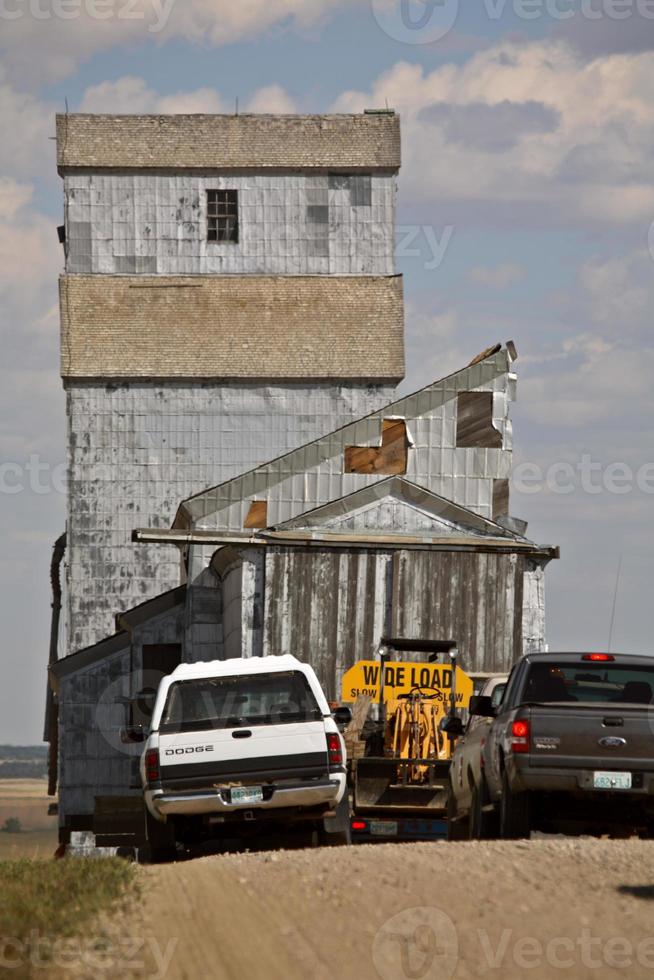 elevador de granos que se mueve a lo largo de la carretera rural de saskatchewan foto