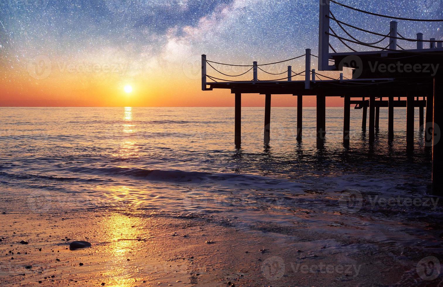 Fantastic starry sky and the Milky Way to the pier at sea, used to natural background sea. Romantic night photo