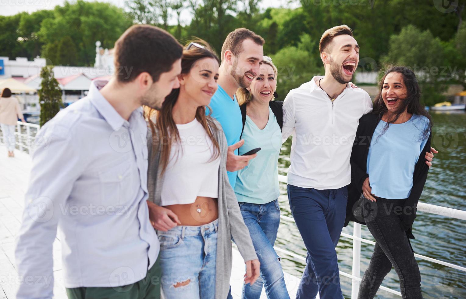 grupo de jóvenes sonrientes y exitosos de vacaciones en el muelle foto