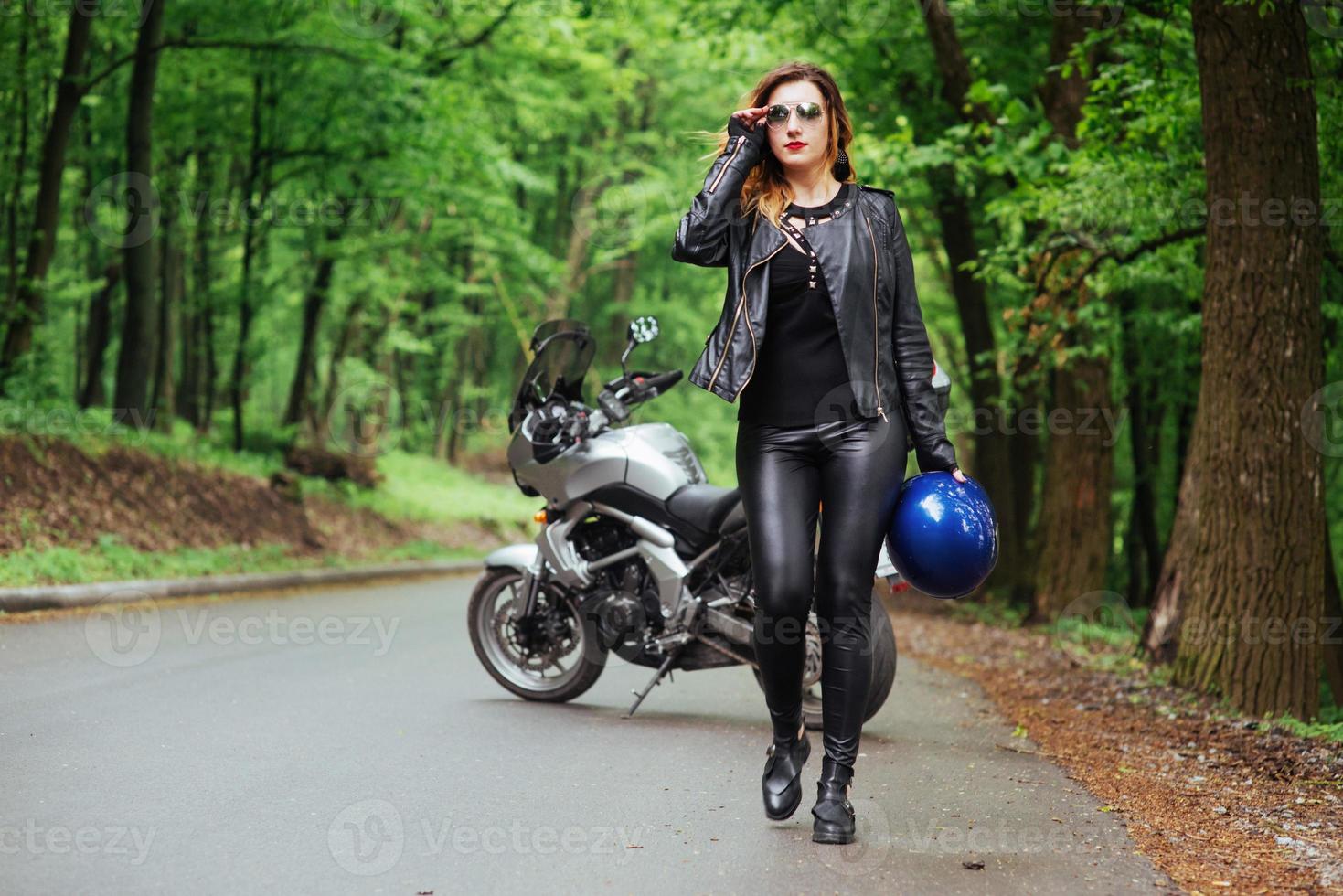 An attractive sexy girl on a sports motorbike posing outside photo