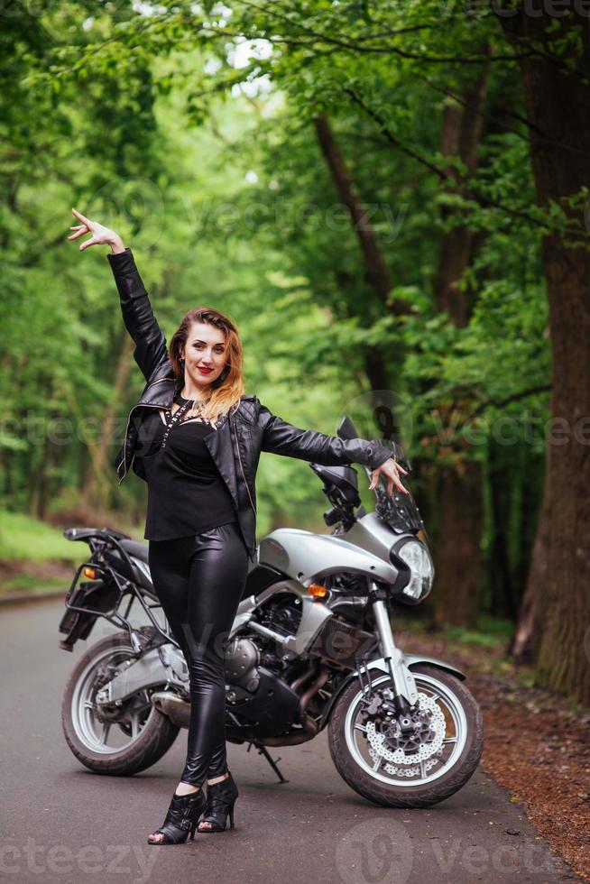 una atractiva chica sexy en una moto deportiva posando afuera foto