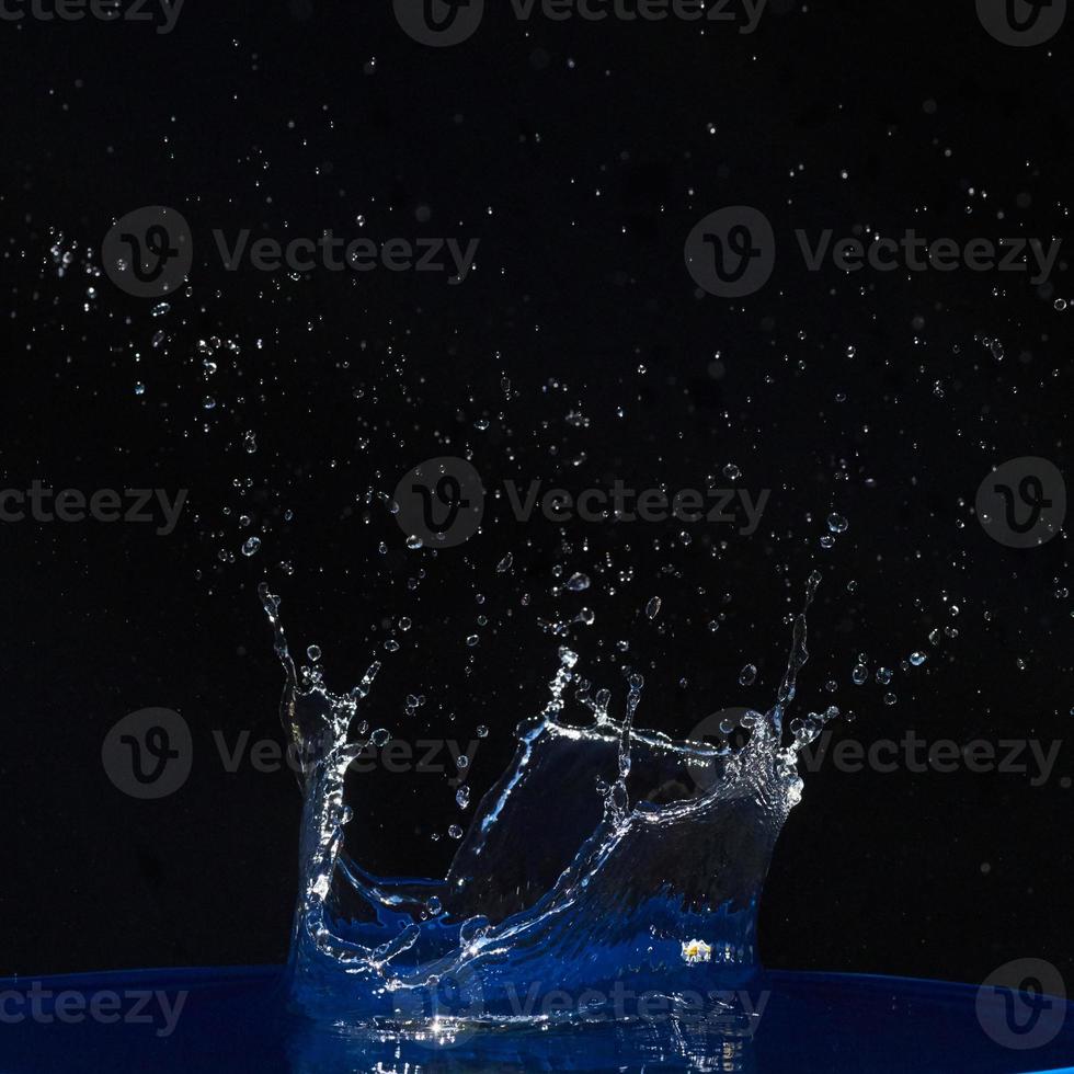 Splash of water crown on blue surface. photo