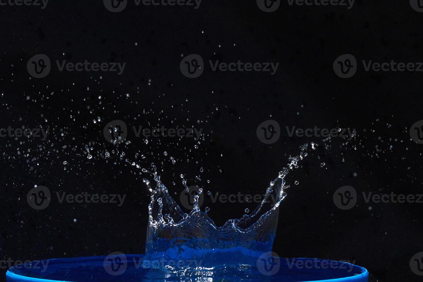 Splash of water crown on blue surface. photo