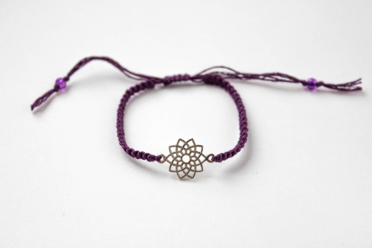 pulsera trenzada púrpura con chakra sahasrara sobre fondo blanco foto