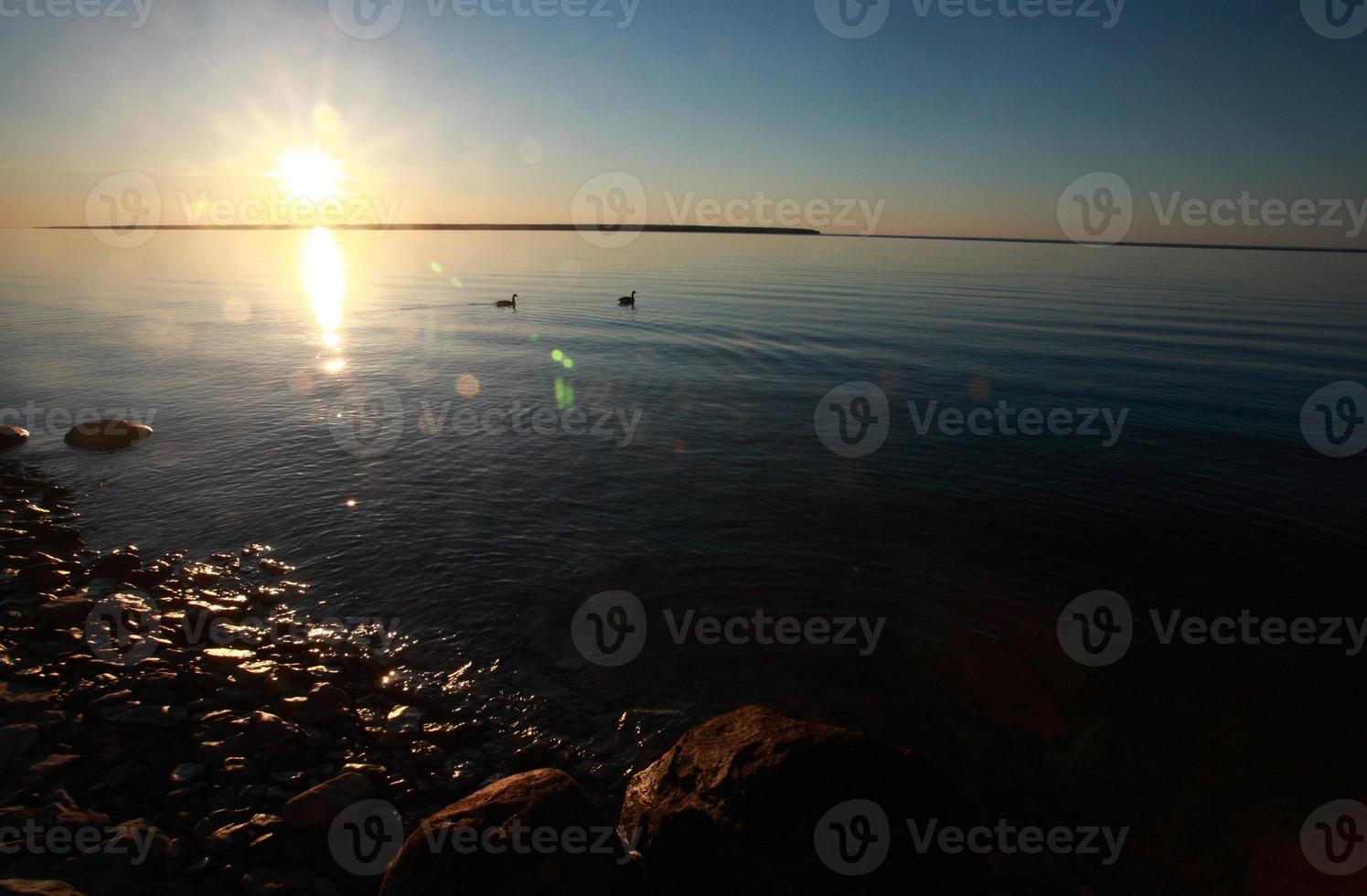 Reflected sunrise along shore of Lake Winnipeg photo