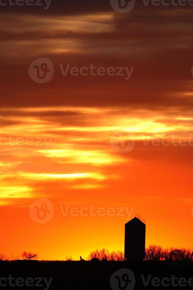Silo silhouetted by colorful sunset photo
