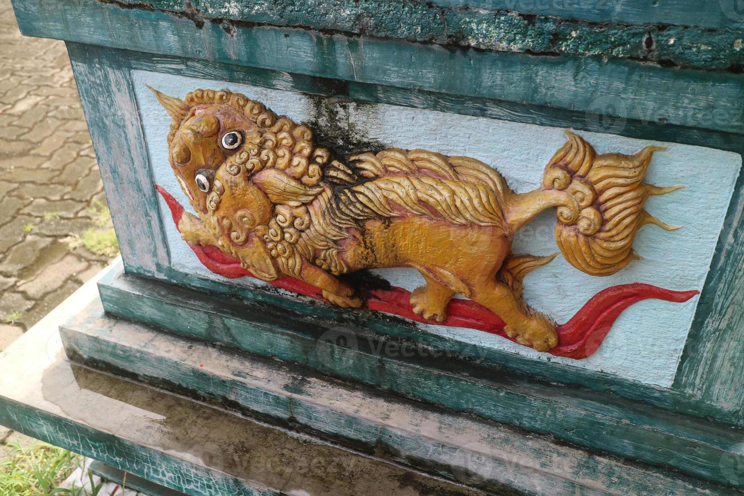 yellow lion carving on the wall photo