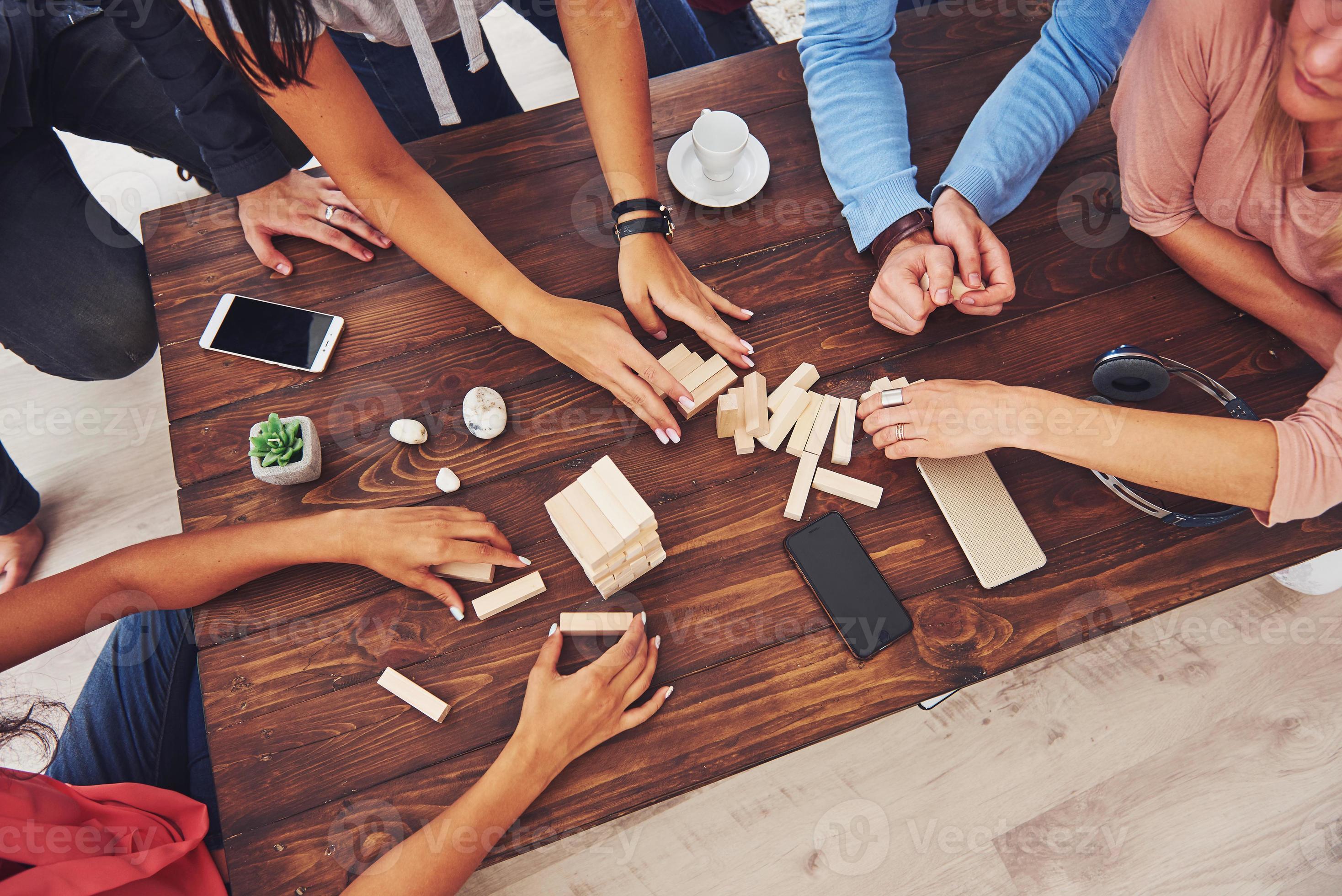 Top view creative photo of friends sitting at wooden table. Friends