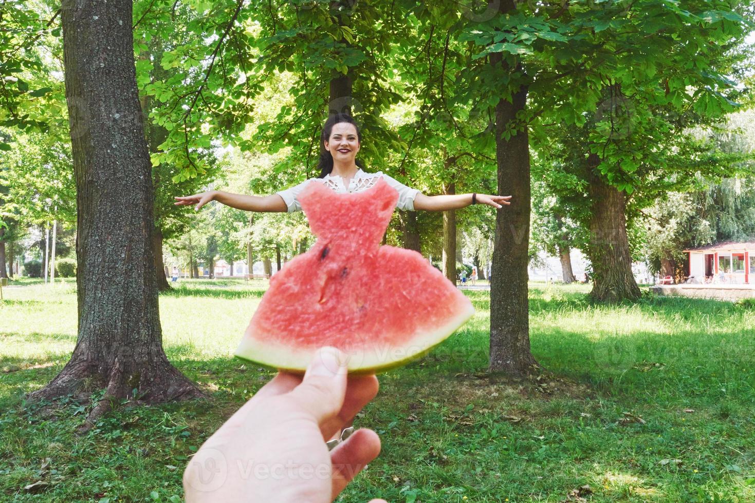 Creative concept photo of a watermelon as a dress with beautiful woman in park