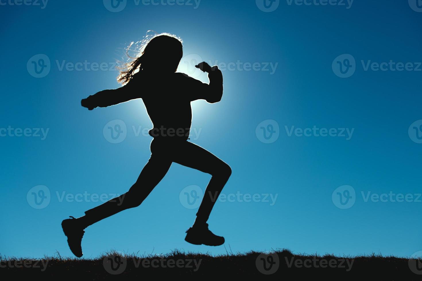 Young girl runs in the meadows photo