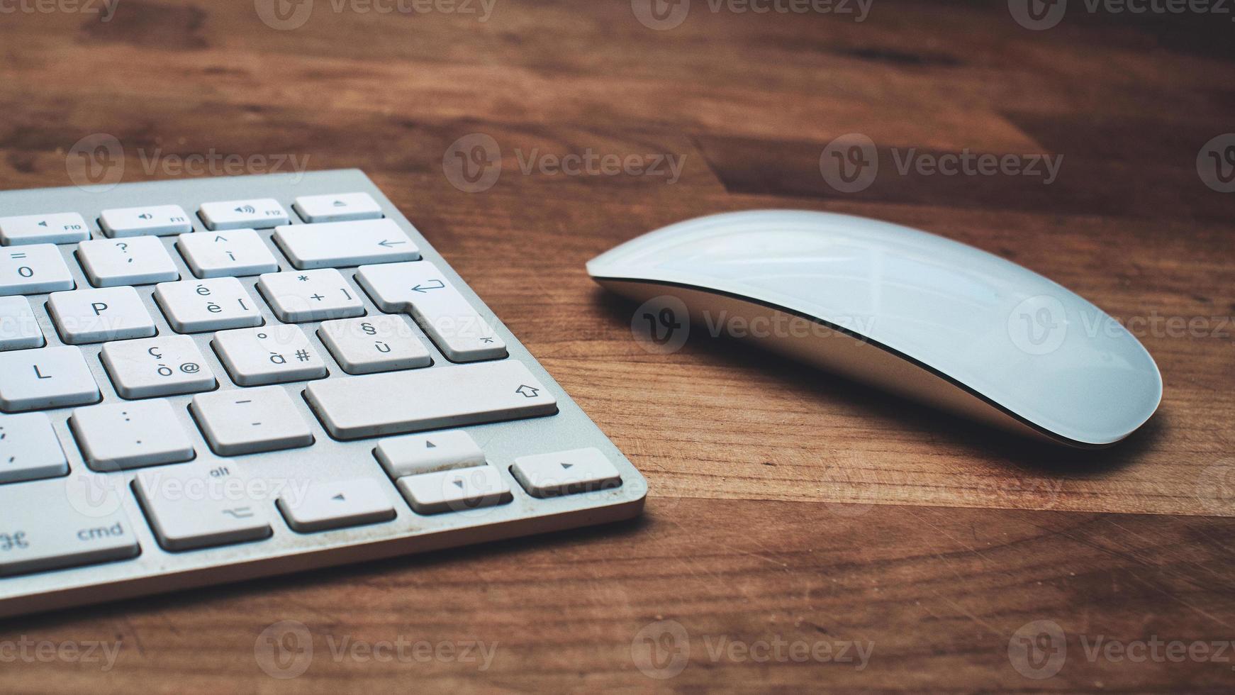 ratón y teclado blancos sobre una mesa de madera foto