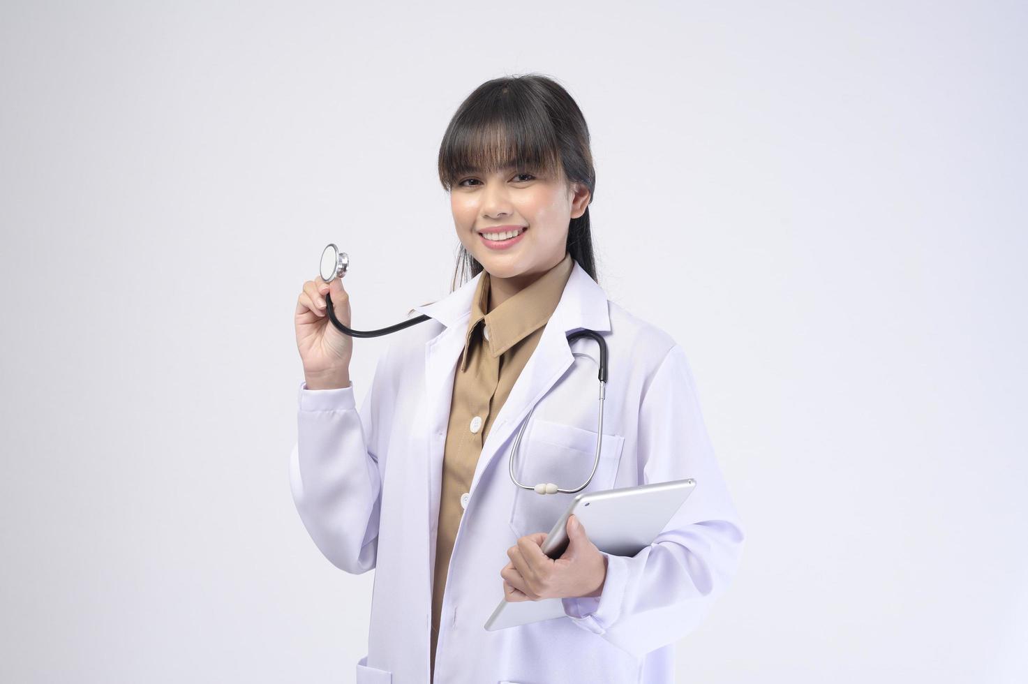 Young female doctor with stethoscope over white background photo