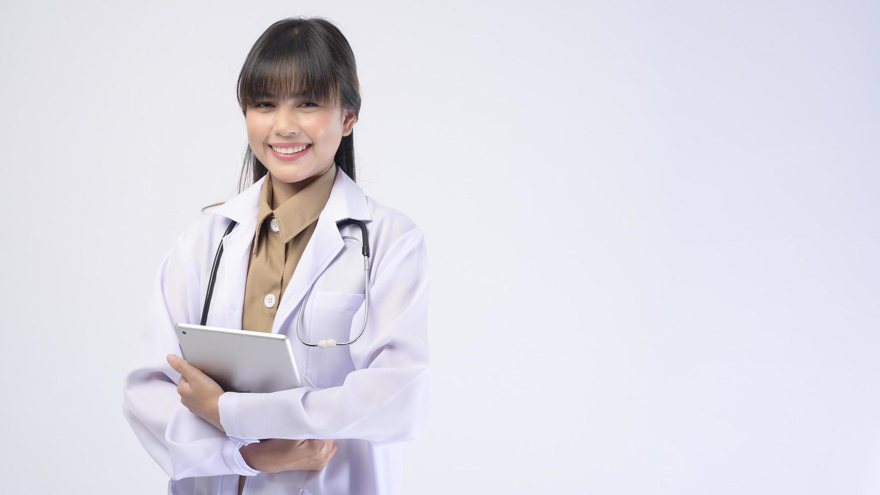 Young female doctor with stethoscope over white background photo