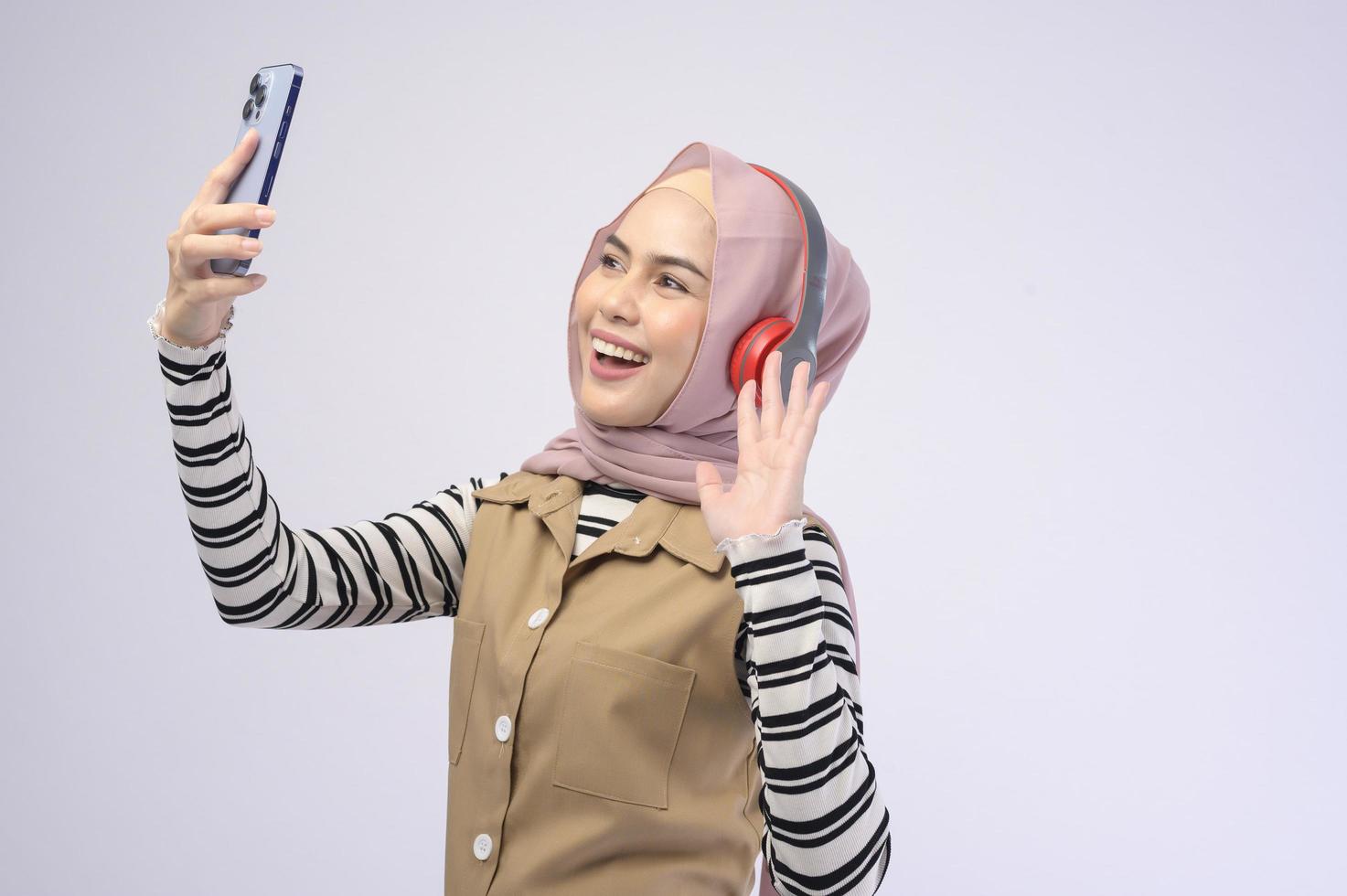 Young beautifu musliml woman wearing headset on white background photo