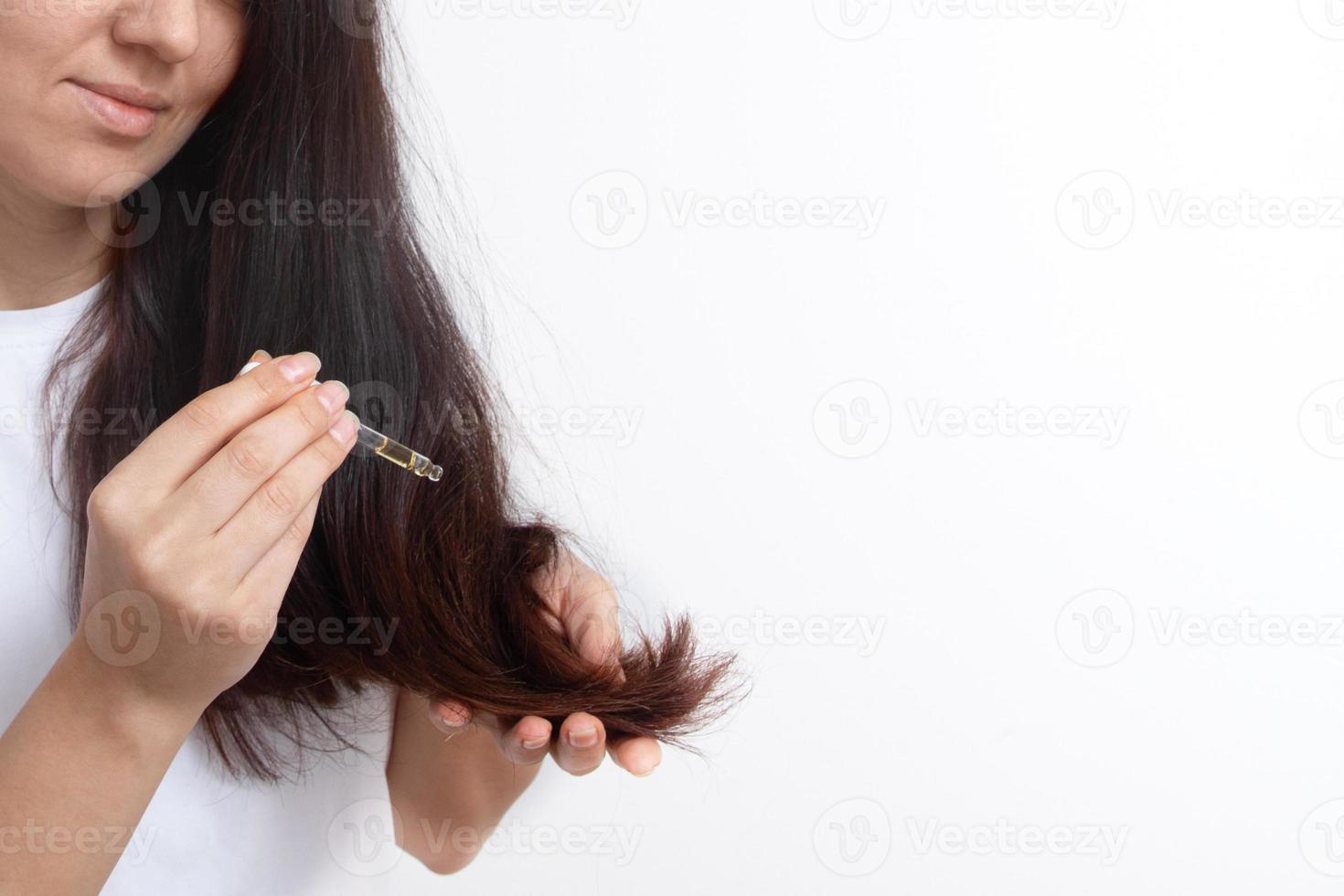 mujer joven con cabello largo y una pipeta en la mano. tratamiento y cuidado del cabello. copie el espacio foto