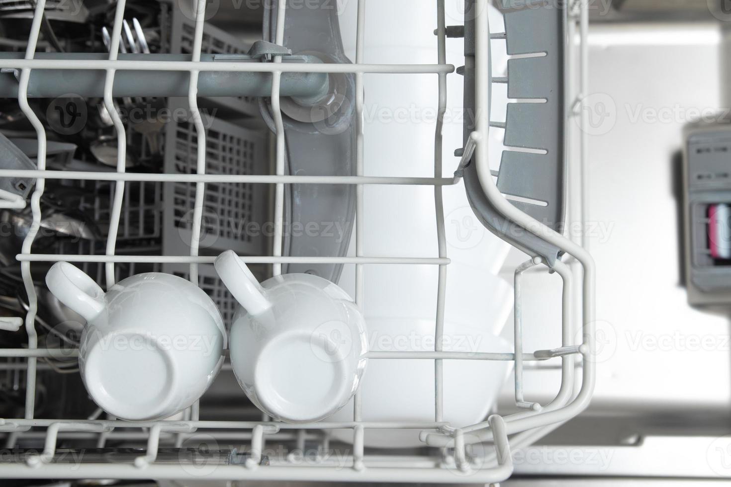 White dishes in the dishwasher. Homework with dishwasher concept photo