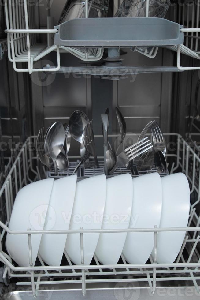 White dishes in the dishwasher. Homework with dishwasher concept photo