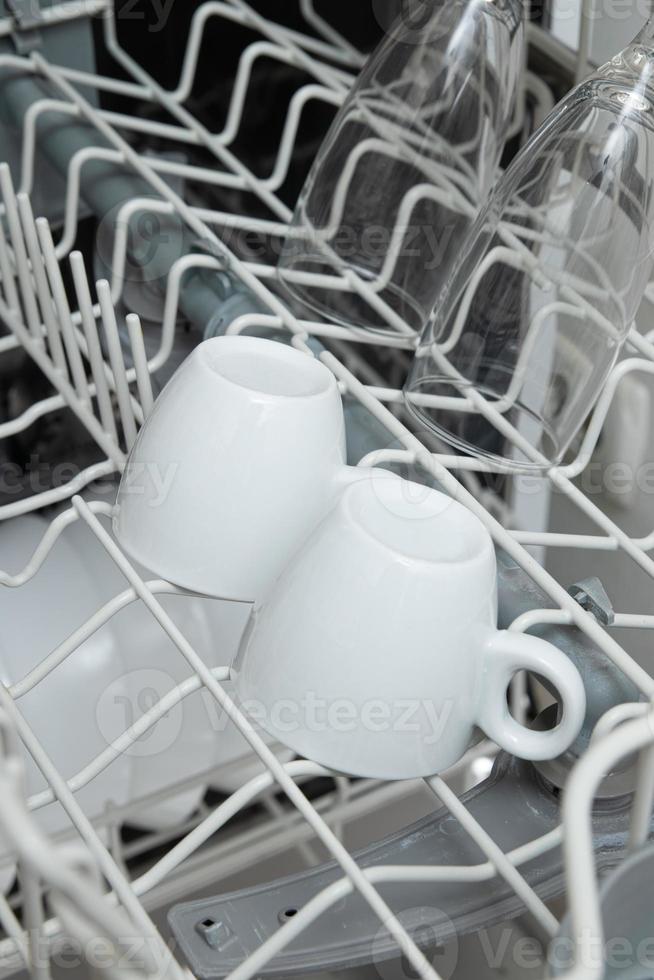 platos blancos en el lavavajillas. tarea con concepto de lavavajillas foto