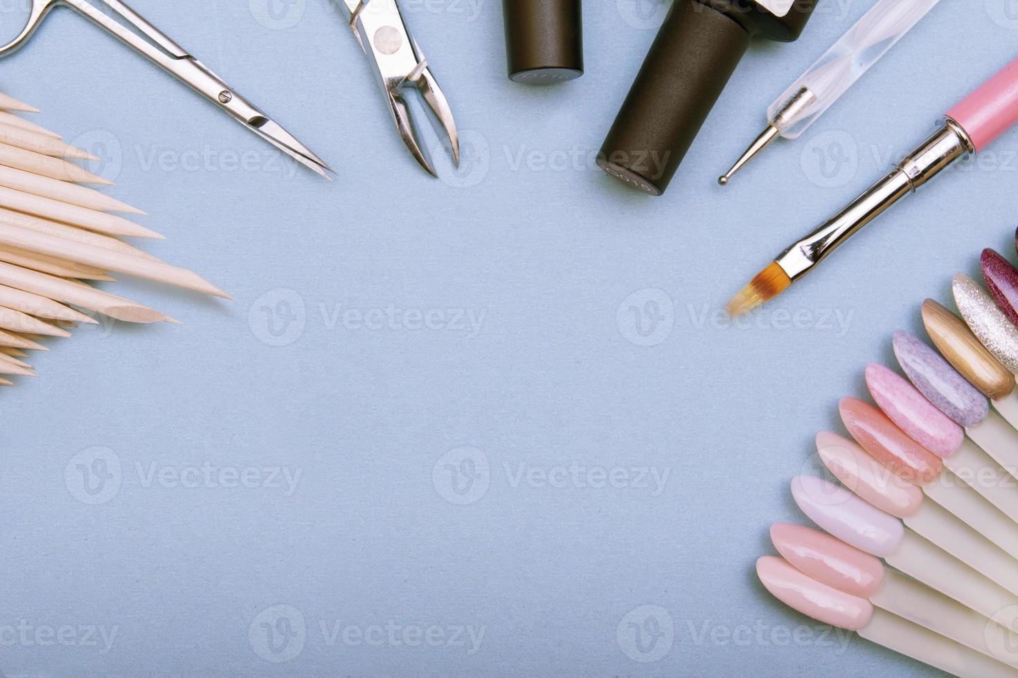 Nail background with professional tools for manicure and gel polish. Top view on a blue surface. Copy space photo
