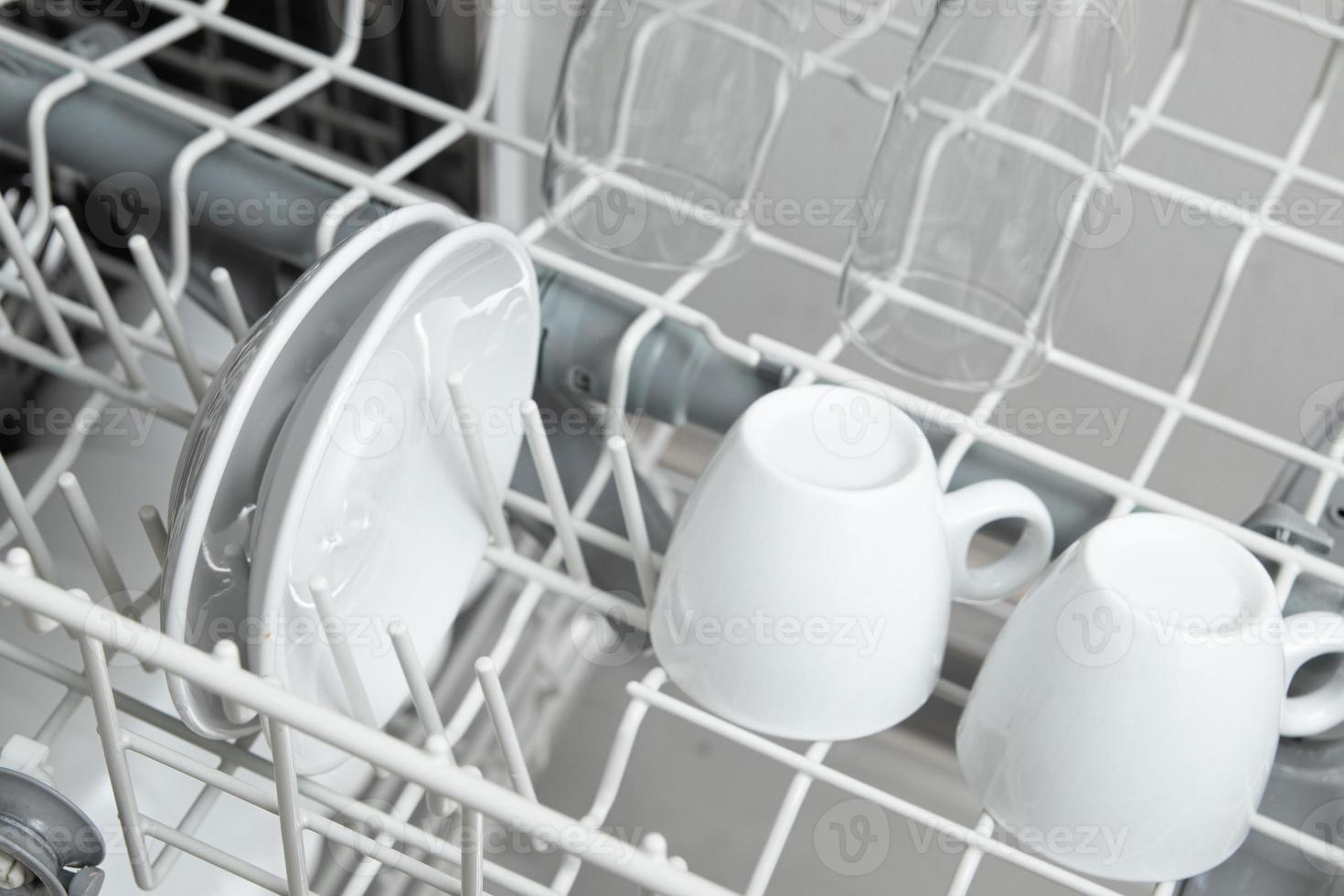 White dishes in the dishwasher. Homework with dishwasher concept photo