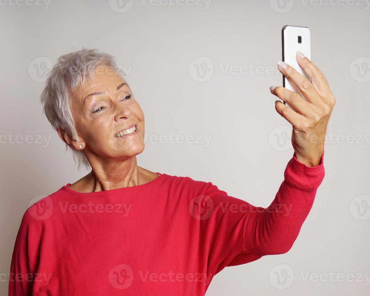 mature woman taking a selfie with smartphone photo
