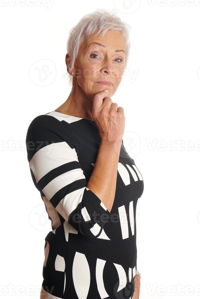 thoughtful older woman with hand on chin photo