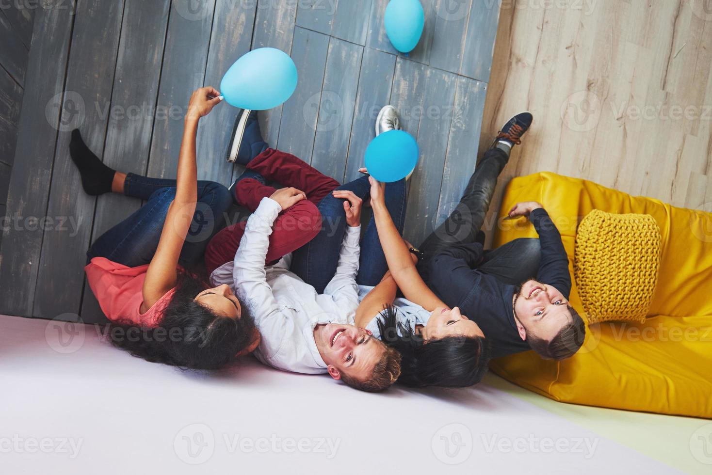 Group portrait of multi-ethnic boys and girls with colorful fashionable clothes holding friend and posing on a brick wall, Urban style people having fun, Concepts about youth and lifestyle photo