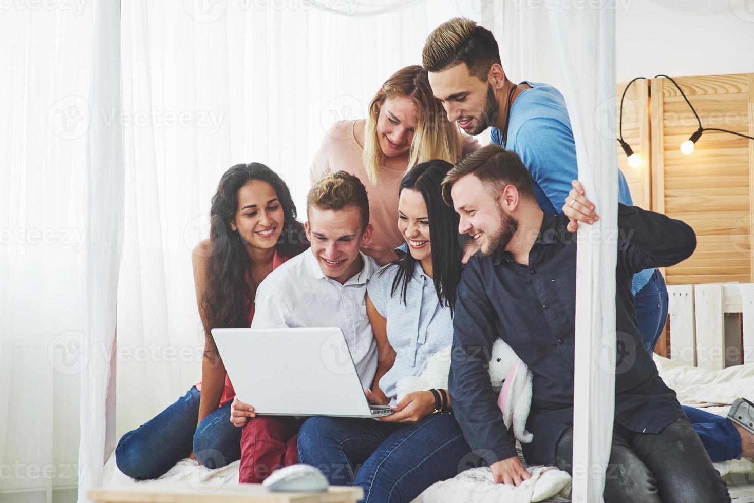 grupo de jóvenes amigos creativos que cuelgan el concepto de redes sociales. personas juntas juegan o ven películas de video foto