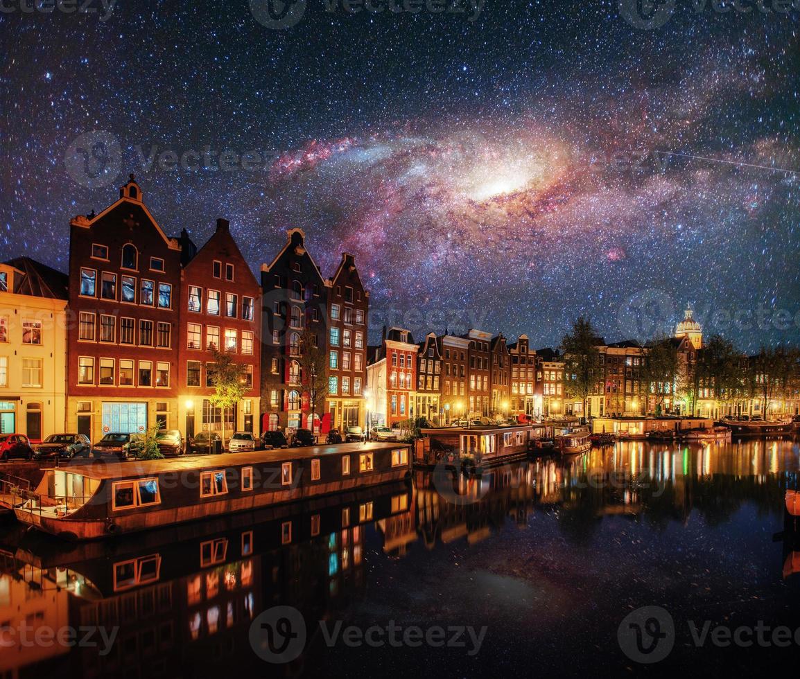 Beautiful night in Amsterdam. Night illumination of buildings and boats near the water in the canal. Courtesy of NASA photo