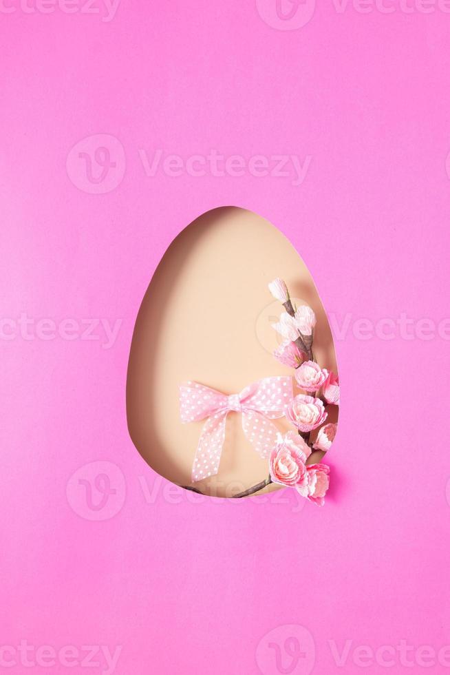huevo de pascua cortado en papel con rama de flor de cerezo. copie el espacio foto