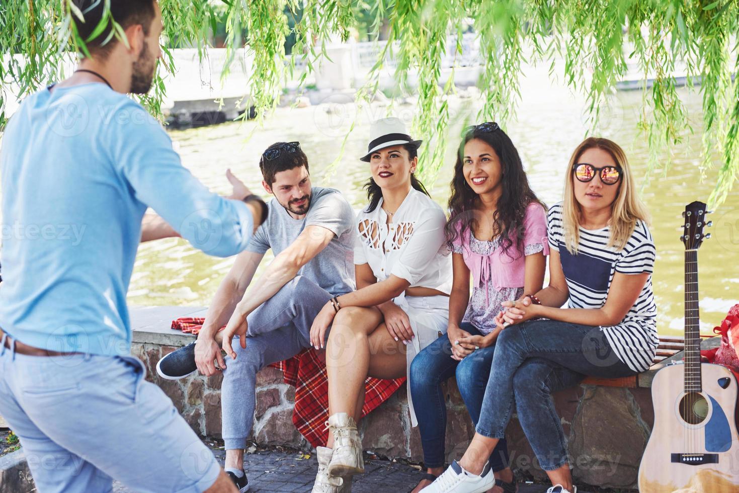 grupo de amigos relajándose y jugando juntos. los jóvenes charlan en las calles, pesan y juegan juntos foto