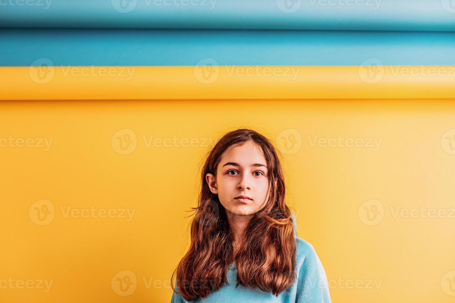 Girl for peace, stop war. Girl in a blue hoodie on a yellow and blue background. photo