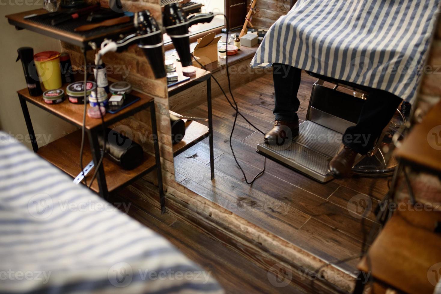 Close up of man's legs in barber chair photo