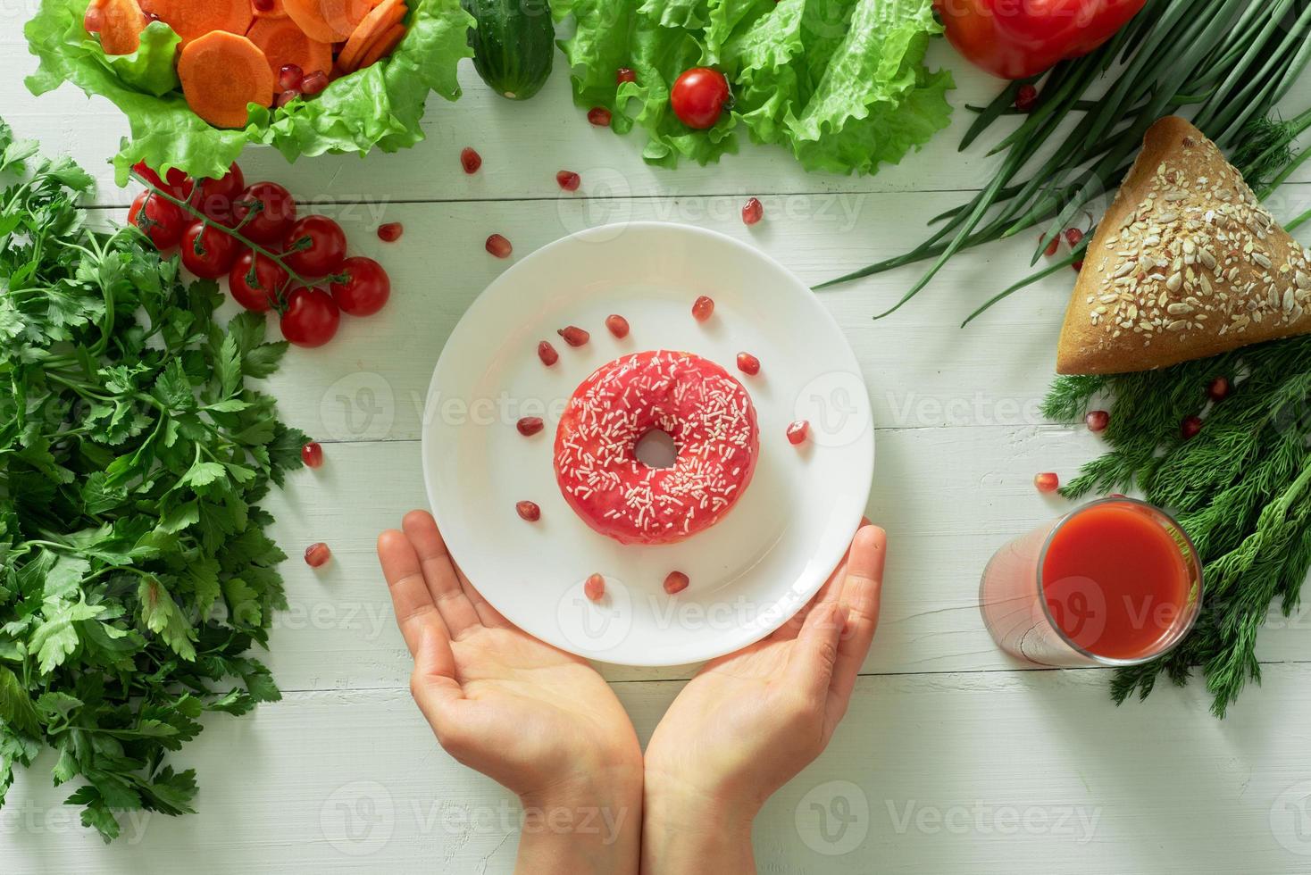 A delicious donut lies on a plate and eats to eat it. Problems of proper nutrition and the concept of choosing between wholesome and not wholesome food photo