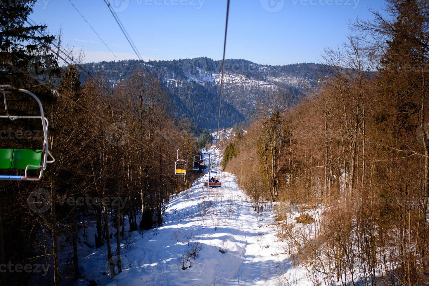 Winter mountains panorama with ski slopes and ski lifts on a cloudy day photo