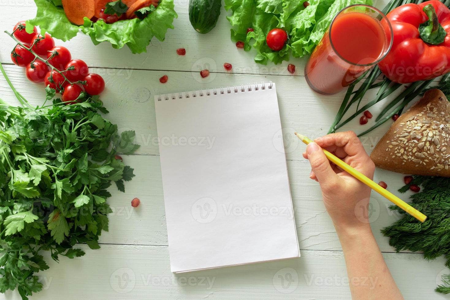 cuaderno para llevar un diario de pérdida de peso sobre el fondo de las verduras. elaboración de una dieta individual. foto