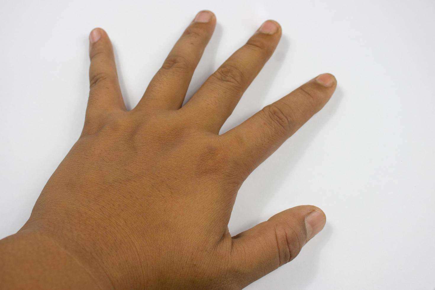 las manos de un joven con tono de piel bronceado, fondo blanco foto