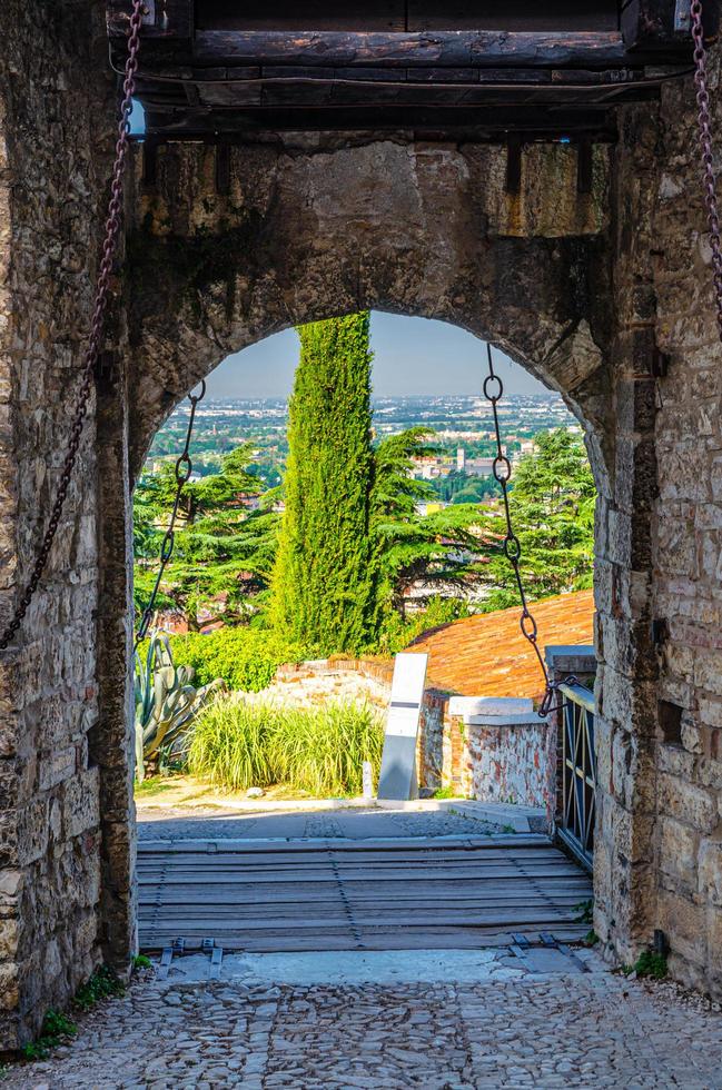 muro de piedra con almenas y puerta de puente levadizo del castillo medieval de brescia foto