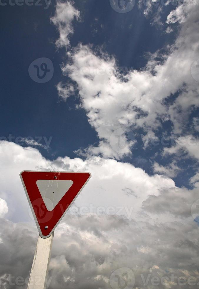 Yeild sign with Cumuloninumbus clouds in background photo