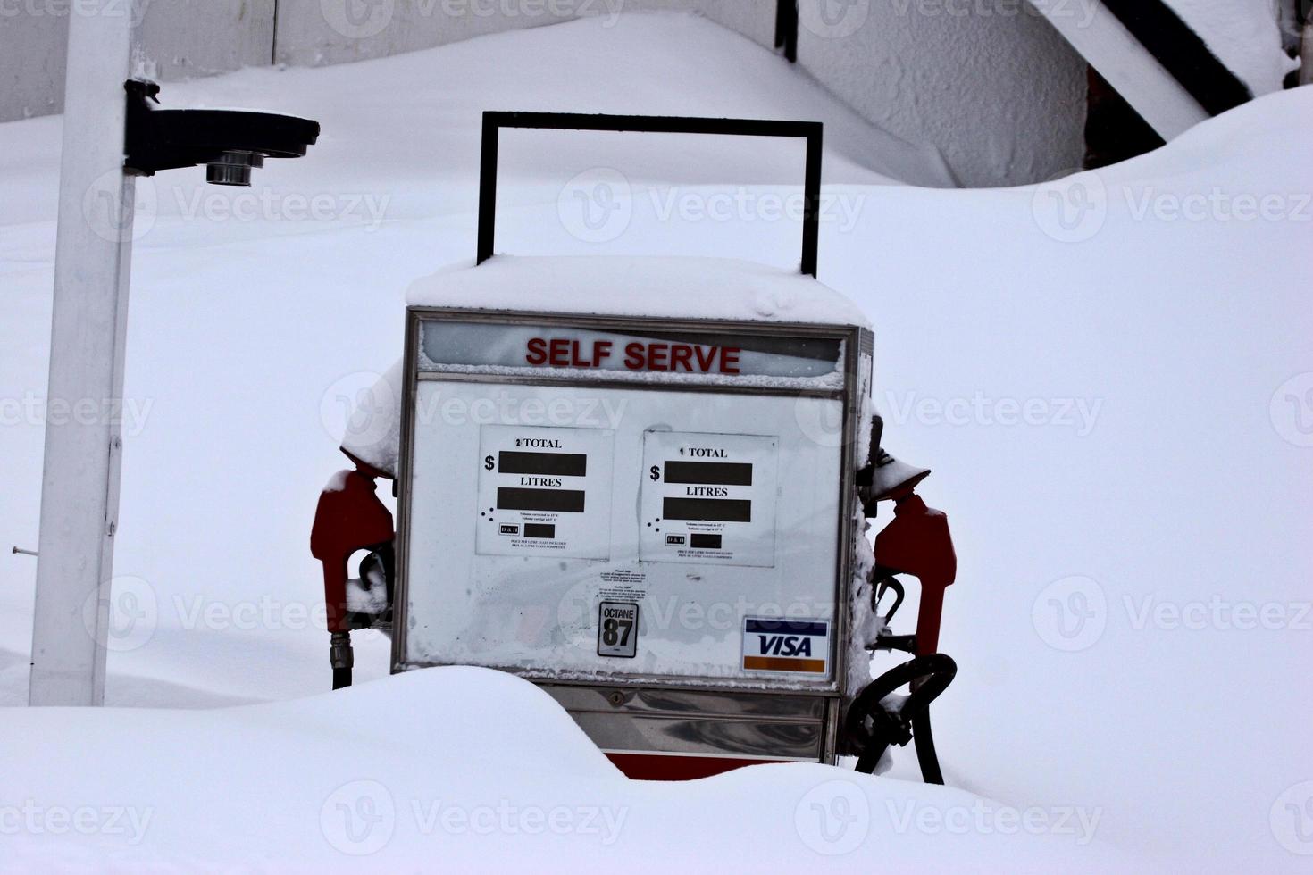 Old gasoline pump covered by snow photo