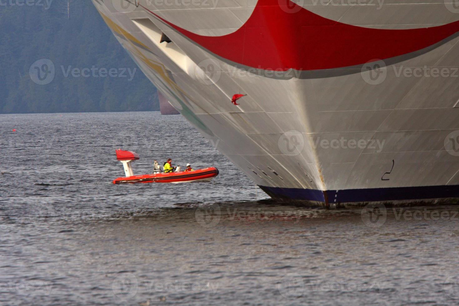 Motor boat passing cruise liner at dock in Prince Rupert photo