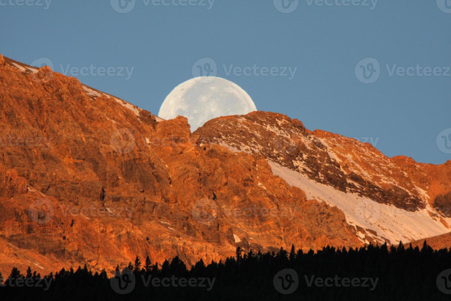 luna llena detrás de la montaña en la pintoresca alberta foto