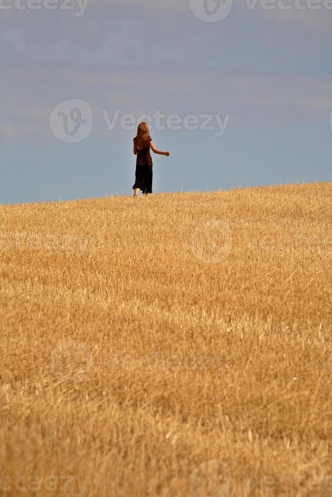 Young girl running in a Saskatchewan stubble field photo