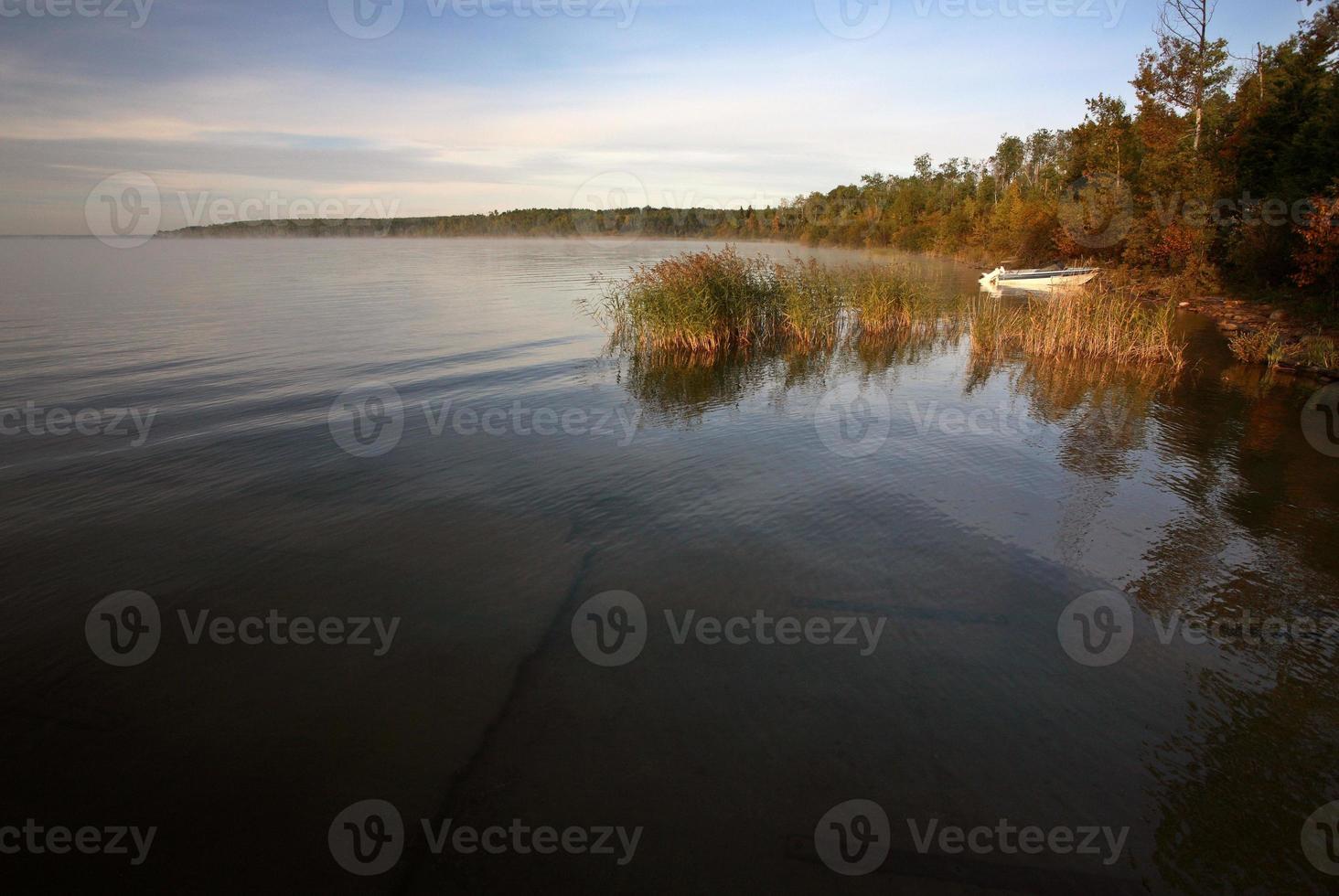 Boat pulled up on shore on Saskatchewan lake photo