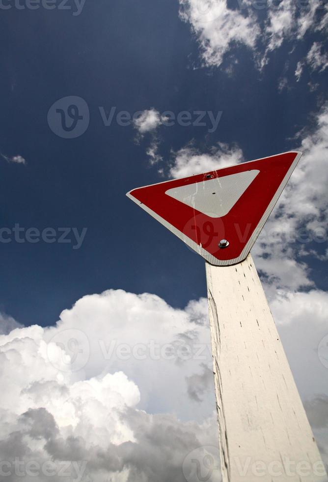 Yeild sign with Cumuloninumbus clouds in background photo