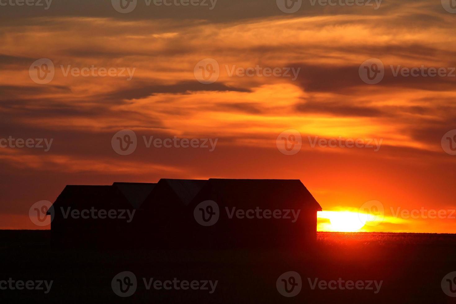 puesta de sol detrás de un edificio agrícola de saskatchewan foto