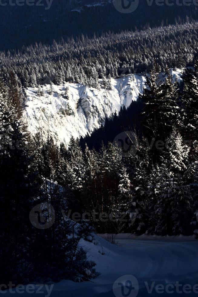 Snow covered cliffs along Alberta road photo